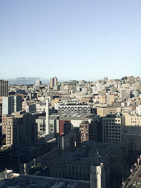 View of the city of San Francisco from a high rise hotel room overlooking a skyline of buildings consisting of home, offices and stores.