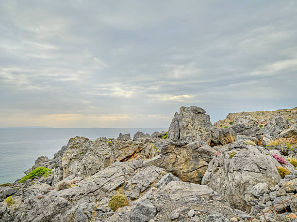 Crete landscape in Greece showcases rugged mountains, rocky hills, and an arid hillside beneath a bright blue sky with white clouds. This natural outdoor scene highlights Greek terrain and scenery, perfect for travel, nature, tourism, and adventure stock projects celebrating Crete and Greece.