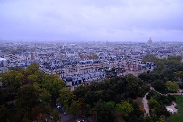High-angle view of Paris cityscape under an overcast sky featuring Haussmann architecture and Les Invalides