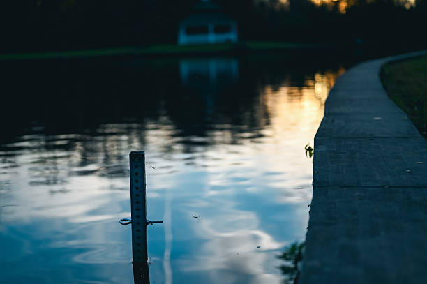 Pond water with light reflections from a beautiful sunset and blurred park pathway