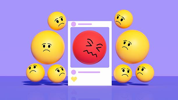 This intense three-dimensional illustration depicts a red, frustrated emoji inside a social media frame, surrounded by sad, frowning yellow emojis. Set against a purple background, the visual represents negative emotions, online conflict, and the spread of bad news or criticism. The red color emphasizes anger or urgent stress, contrasting with the disappointment of the surrounding faces. This design is ideal for illustrating topics like cyberbullying, negative feedback, crisis management, or the emotional impact of social media interactions on a community.