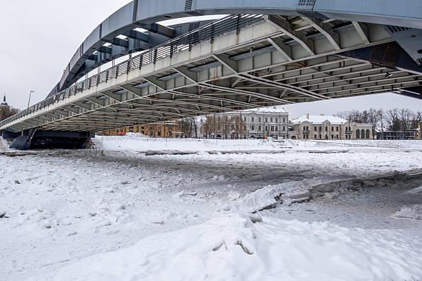 Winter cityscape of Vilnius, Lithuania, featuring the frozen Neris River. Snow-covered ice formations , ideal for climate, winter weather, urban lifestyle, and European city concepts.