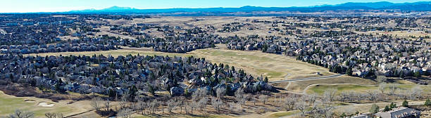 Panorama view curving streets near the small commercial pocket off E Arapahoe Rd shape dense residential grid. Mixed roof hues, parked cars, soft seasonal foliage visual depth, Aurora, Colorado. USA