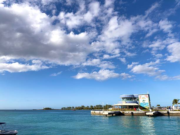 Nassau, Bahamas - January 7, 2026: Waterfront view of Nassau harbor in the Bahamas, featuring a resort building with a colorful mural under a beautiful blue sky with scattered clouds, showcasing a tropical travel destination