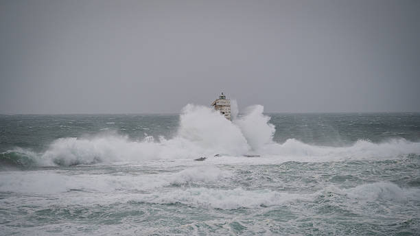 Powerful sea spray engulfing lighthouse tower, Mangiabarche Lighthouse