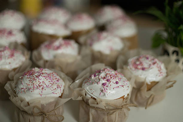 Creamy pink muffins assortment close-up.Fresh sponge cakes with pink cream.Sweet pastries and desserts. Fragrant appetizing pastries.