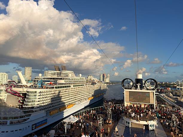 Miami, Florida, United States of America - January 5, 2026: Two giant cruise ships docked at Port Miami with crowds on deck enjoying sunny skies and city skyline, leisure travelers and vibrant waterfront activity in Florida harbor