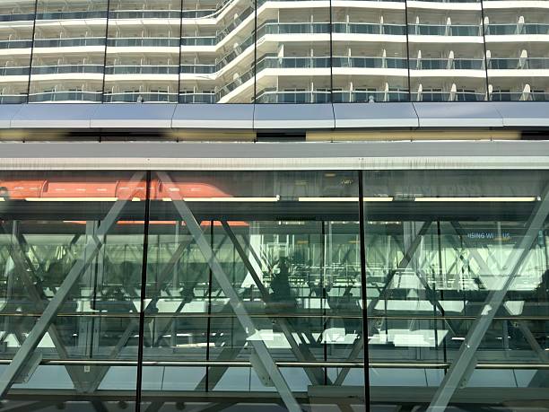 Modern glass and steel cruise terminal gangway connecting to a large cruise ship docked in Miami, Florida, offering views of passenger boarding for travel and vacation