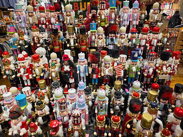 Large collection of colorful wooden nutcracker figurines displayed together in a festive market setting. The traditional soldier dolls feature ornate uniforms, tall hats, and classic holiday designs associated with Christmas decor and European seasonal traditions. Ideal for concepts related to winter holidays, festive decorations, toy craftsmanship, and seasonal retail displays.