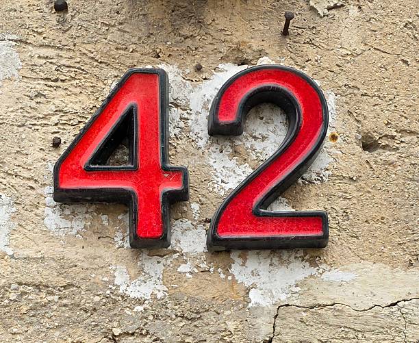 Red Number 42 with Black Outline. House Number on a old Stone Wall in Budapest.