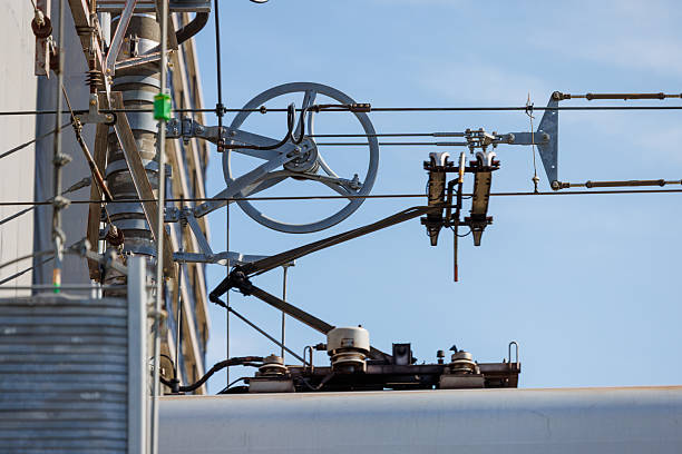 Close-up of railway overhead contact lines, a pulley-type tension balancer, and a pantograph. This device keeps the wire tension constant.
