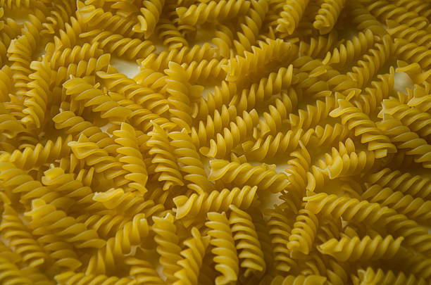 Detailed close-up of raw fusilli pasta spirals, showcasing texture and shape. Perfect for food-related concepts.