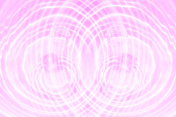Pink water bubbles on the surface ripples. Defocus blurred transparent pink colored clear calm water surface texture with splash and bubbles. Water waves with shining pattern texture background