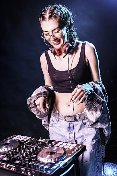A DJ mixes music at a dance party with a controller and connects with the audience.