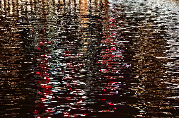 Shimmering red and white streaks across rippled surface