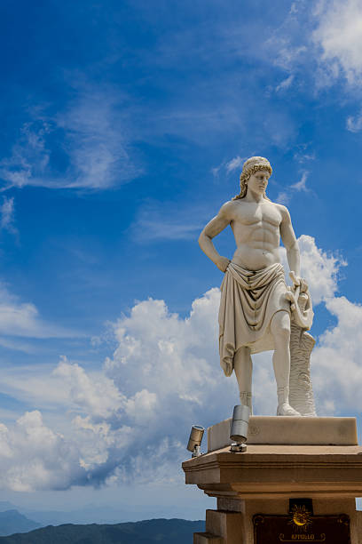 A statue of the Greek god Apollo set against a bright blue sky in Vietnam. The scene highlights classical sculpture details and contrasts traditional Western mythology with the Vietnamese outdoor setting, creating a striking and photogenic cultural landmark. A vibrant and sunny travel and art-focused composition.