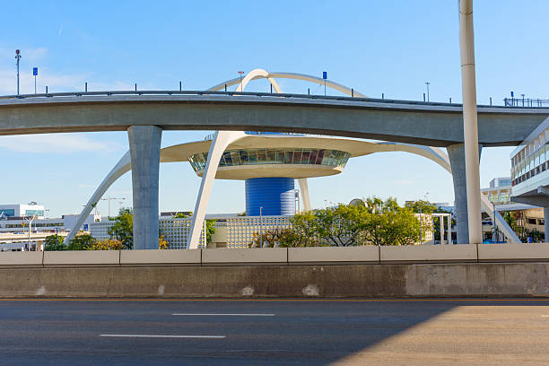 Los Angeles, California - January 12, 2026: LAX Theme Building stands as a Googie architecture landmark at Los Angeles International Airport, framed by concrete highway overpasses and a clear sky