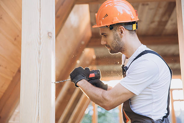 Construction worker working with screwdriver on wooden frame, diy eco-friendly homes concept. Man using drill working on construction of wood modular house