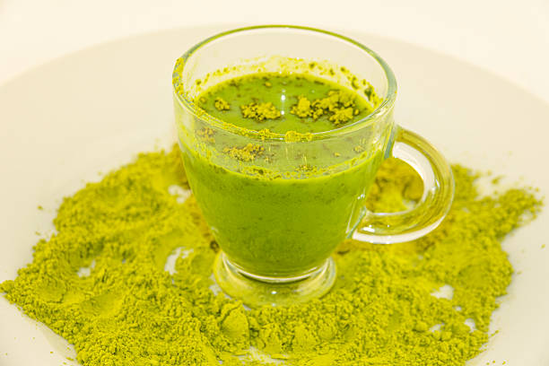 A green drink cup on a plate of matcha
