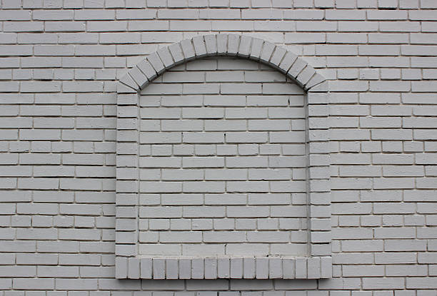 An arched window completely bricked up by a solid layer of bricks