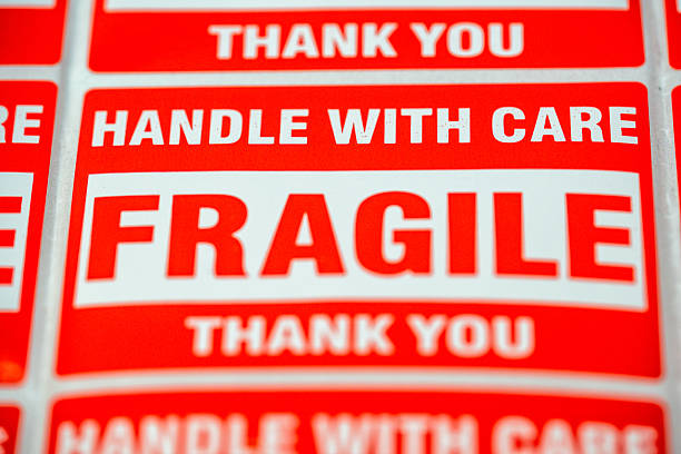 istock Labels that say fragile and handle with care are arranged on a surface for shipping items in a busy storage area during daytime hours 2261795689