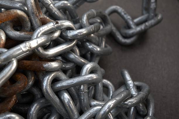 Close-up of rusty metal chain texture used as background, symbolizing strength, aging, decay, and passage of time. High value concept of resilience, restriction, and industrial symbolism.