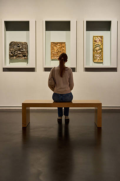 visitor in historical museum looking at art object