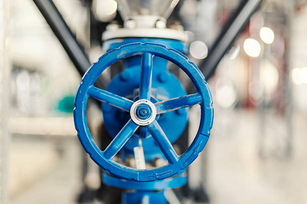 Blue industrial valve wheel playing an important role in controlling the flow within a complex pipeline system, ensuring operational efficiency and safety in a factory