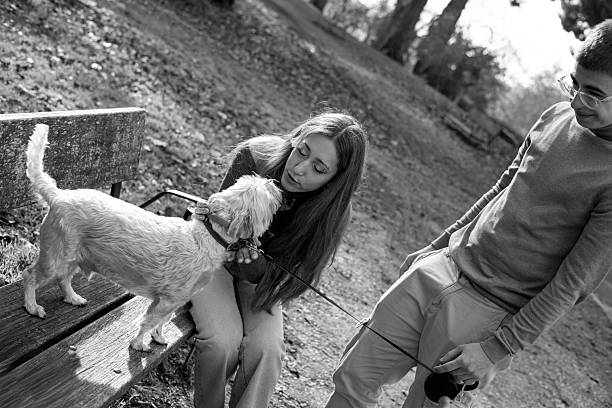 Young couple and their dog enjoying companionship on a park bench outdoors