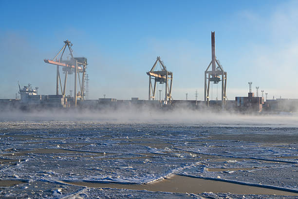 Frozen Daugava River on a winter morning and port cranes