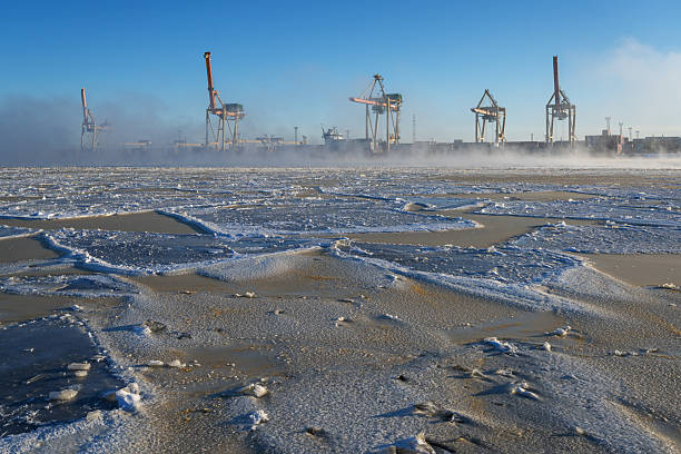 Frozen Daugava River on a winter morning and port cranes