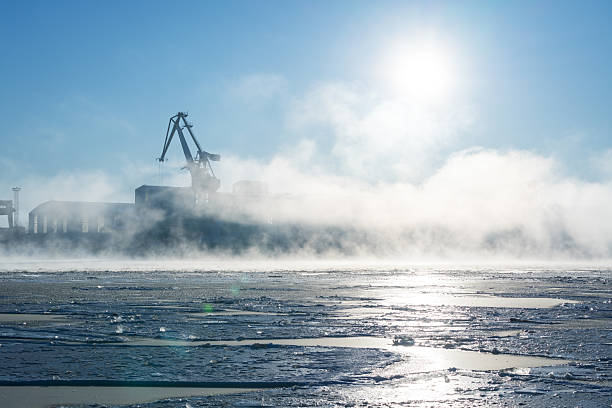 Frozen Daugava River on a winter morning and port cranes