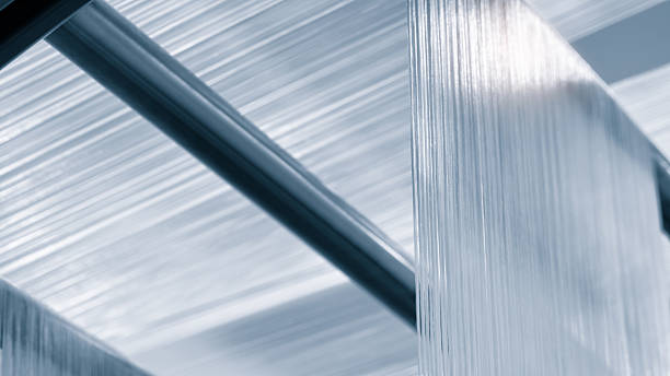 synthetic textile thread,  thread at industrial weaving manufacturing machine,  textile fabric production industrial concept background