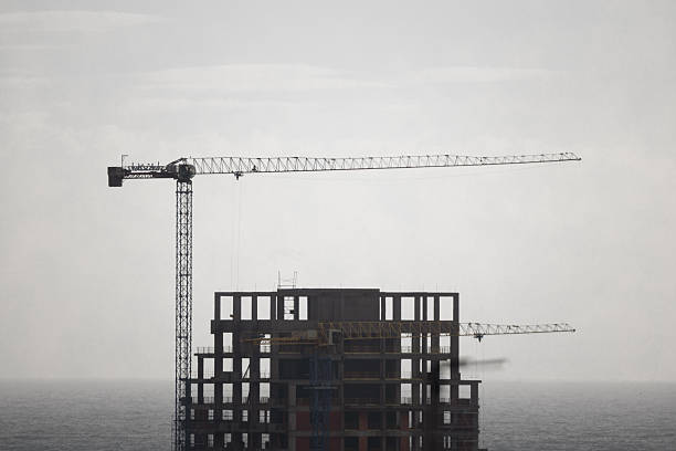 Construction crane and building in front of the sea