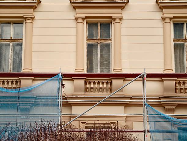 An old building in scaffolding during renovation and painting of the facade.