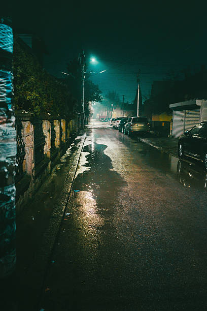 Small dark street, night scene in the rain, town of Cacak in Serbia during winter without snow.