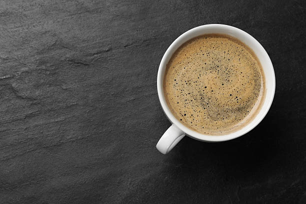 istock Cup of aromatic coffee on black table, top view. Space for text 2261889631