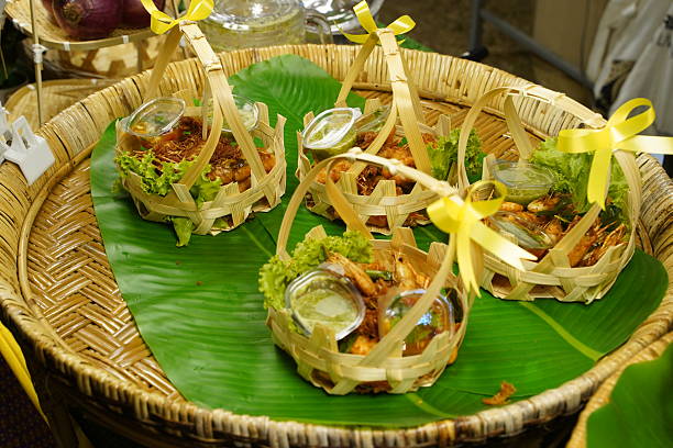 Variety of authentic Thai street food snacks, grilled pork skewers, and meatballs at a local night market.