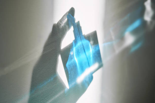 A transparent glass perfume bottle with intricate detailing placed on a shelf.