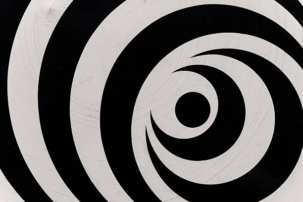Bold black and white spirals converge to form a mesmerizing pattern that draws the viewer into a captivating visual experience. The artwork exudes a sense of motion and depth.
