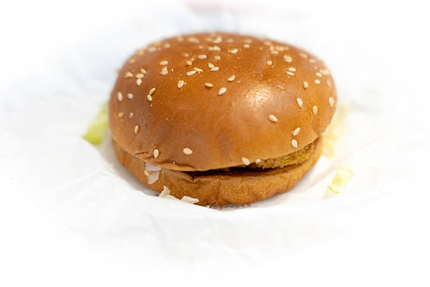 Sesame seed burger with crispy patty and fresh lettuce on white wrapper