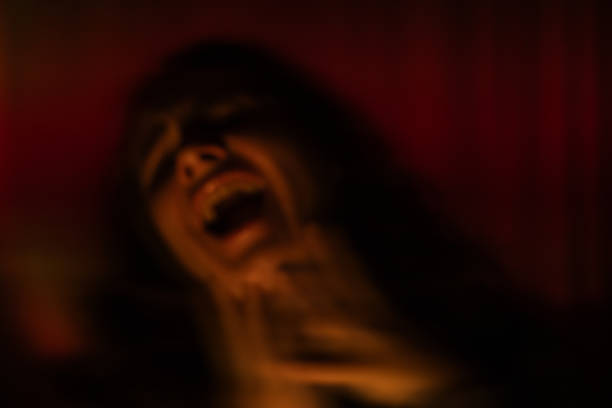 Blurred bokeh of screaming woman on red background