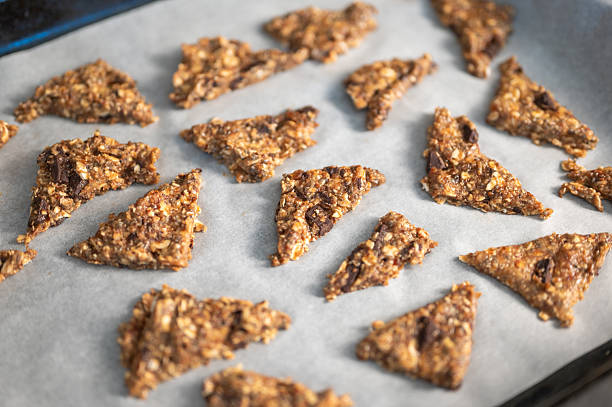 Homemade granola cookies arranged on parchment paper, showcasing healthy ingredients like oats and chocolate, perfect for a nutritious snack or breakfast option.
