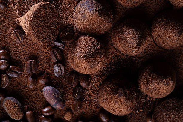 art background with healthy delicious dark truffles, chocolate  and  ingridients:  natural cocoa beans,  powder, cacao butter, cane sugar. healthy sweets concept. flat lay. macro shot