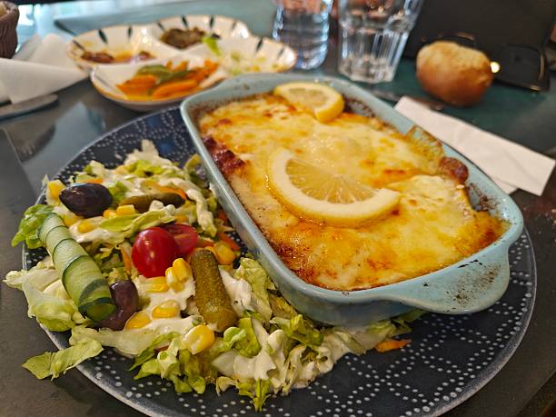 Lasagna bolognese close up. Served traditional Italian cuisine. DIsh with pasta, meat, tomato sauce, grated cheese and basil leaves in plate. Italy culinary. Restaurant food portion, main course. High quality photo
