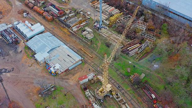 Aerial view showing an old industrial yard with a yellow crane and various metal structures