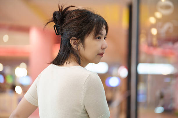 Asian woman relaxing inside shopping mall, calm female enjoying leisure time and casual lifestyle