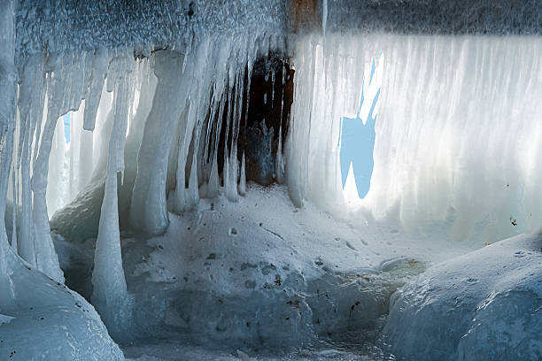 Pier supports transformed into dramatic ice formations, with thick layers of frozen water and floating ice fragments creating a striking winter coastal scene