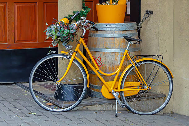 Retro bicycle with yellow frame tied up on a local city street