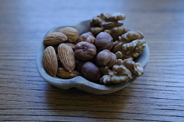 Almonds, hazelnuts and walnuts in a small wooden cup; healthy food; healthy food for gut healing